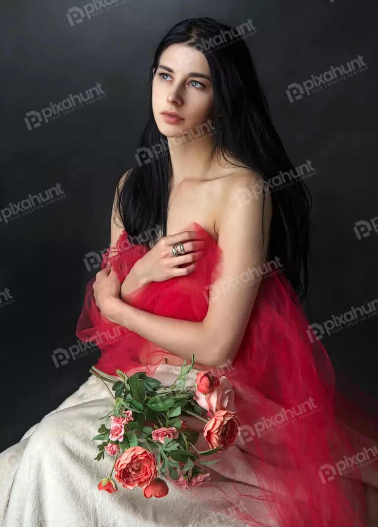 Elegant Woman Draped in Red Tulle with Flowers, Contemplative Gaze