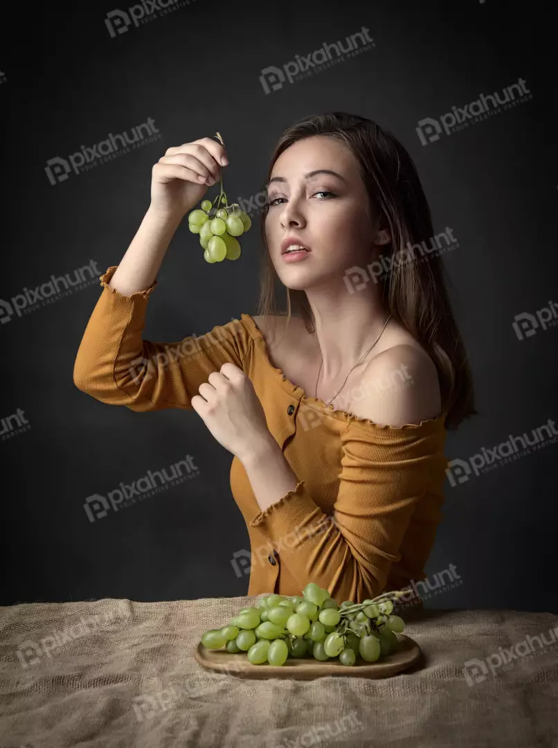 Fashionable Woman Posing with Fresh Green Grapes in Mustard Off-Shoulder Top