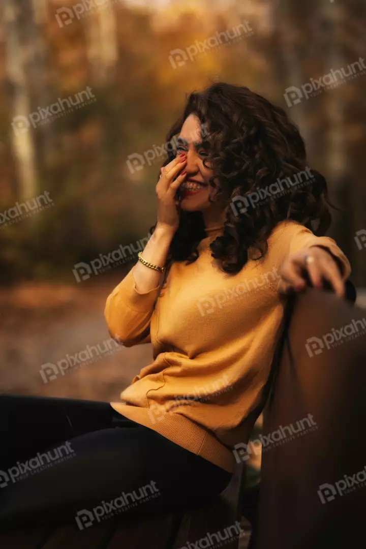 Free Premium Stock Photos Cheerful brunette curly hair woman smiling in a park with fall foliage and smileing