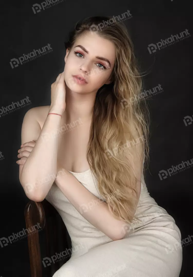 Elegant Young Woman in Ribbed Cream Dress on Wooden Chair