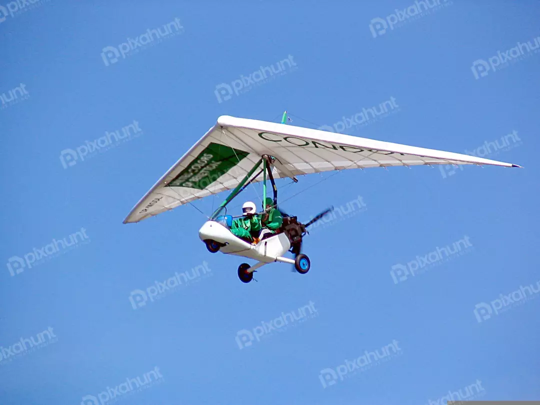 White and Green Ultralight Trike Soaring in Sunny Sky with Pilot