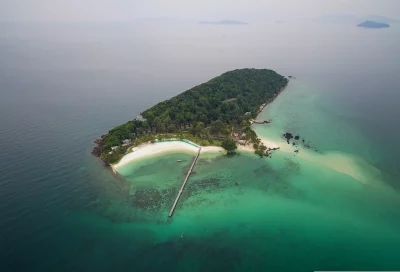 island drone view | aerial view of a tropical island is surrounded by a crystal-clear sea and has a lush green forest
