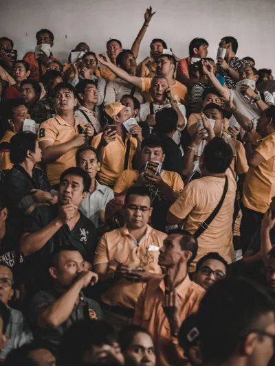A large group of people mostly men or gathered together in a stadium