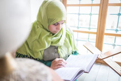 Muslim Woman Reading holy Quran very carefully