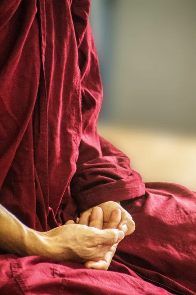 Buddhist monk meditate to calm the mind. Focus on placing hands in meditation.