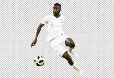 Osama Hawsawi is wearing a white jersey with green shorts and socks