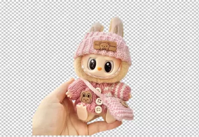 Whimsical Plush Character in Knitted Pink Attire Cradled by Human Hand image