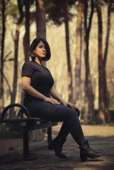 Casual Woman in Black Sitting on Park Bench