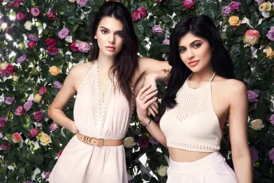 Kendall and Kylie Jenner Posing Elegantly Against Rose Flower Wall image
