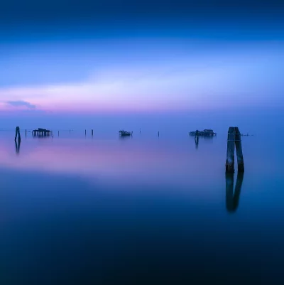 Serene Misty Lagoon Sunset with Wooden Huts Cinematic Wallpaper image