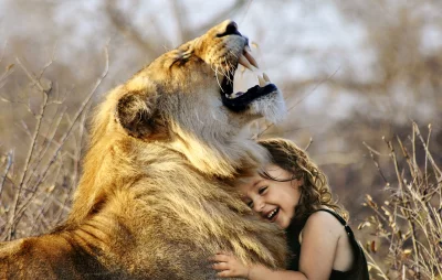Joyful Child Hugs Majestic Lion While Roaring in Nature image