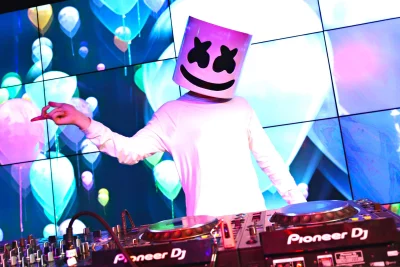 Electronic DJ Performance with Marshmello-Style Helmet, Vibrant Neon Stage Lights, and Music Mixer image