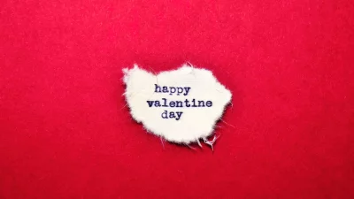Heartfelt Happy Valentine Day message on torn white paper on red background image