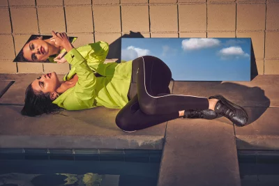 Athletic Woman in Neon Yellow Jacket Reflecting in Mirrors by Poolside image