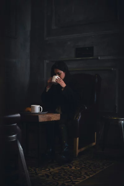 Woman enjoying a cozy moment with coffee and croissant indoors