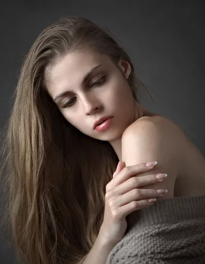 Elegant portrait of a thoughtful woman with long, natural hair and delicate French nails image