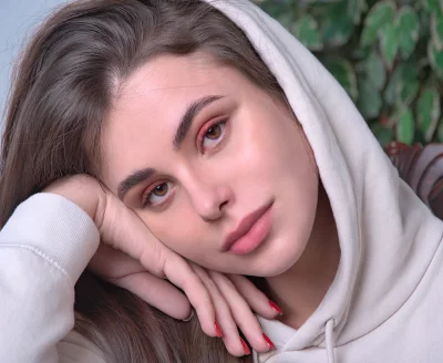 Thoughtful Young Woman Leaning Head on Hand in Casual Hoodie Captivating Stock Photo image