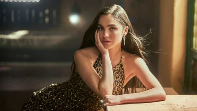 Sparkling Young Woman in Gold Sequin Dress Posing Confidently in Evening Light image