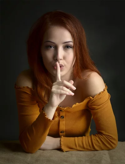 Redhead Woman Silencing with Finger on Lips Secretive Gesture image