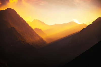 Golden Light Rays Piercing Mountain Valley at Sunset image