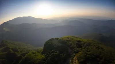 Sunrise Over Misty Mountain Range with Lush Green Forest