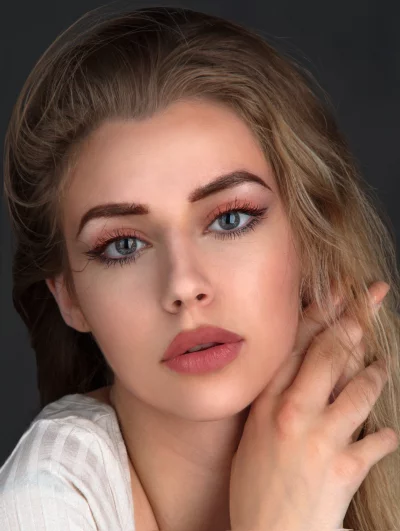 Blonde Woman's Close-up Portrait with Expressive Blue Eyes and Gentle Hand Gesture image