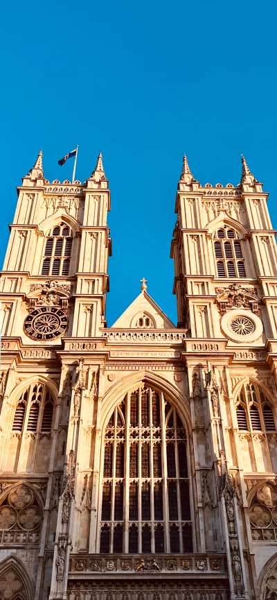 Historic Westminster Abbey towers under a clear blue sky