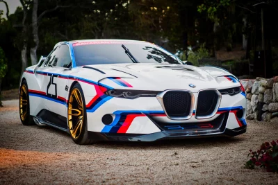 Sleek White BMW Concept Car with Striking Blue and Red Racing Stripes and Gold Wheels Parked Outdoors image