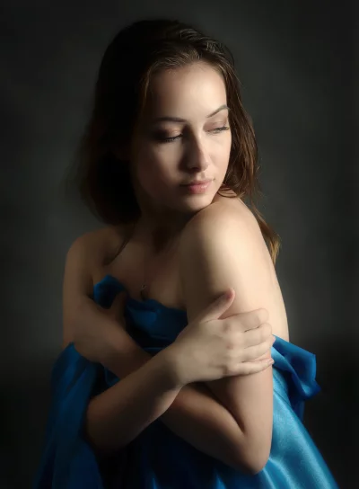 Pensive Young Woman Draped in Blue Silk Fabric, Elegant Studio Portrait image