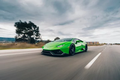Dynamic Green Lamborghini Supercar Accelerating on Open Highway Under Dramatic Cloudy Sky image