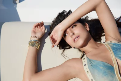 Glamorous Young Woman Shielding Eyes in Stylish Blue Dress and Gold Jewelry image
