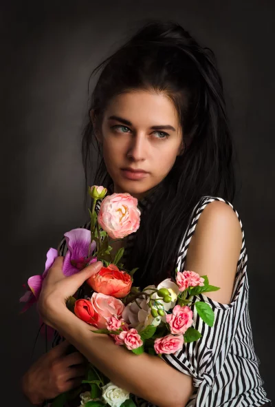 Captivating Woman with Blue Eyes Holding Vibrant Floral Bouquet image