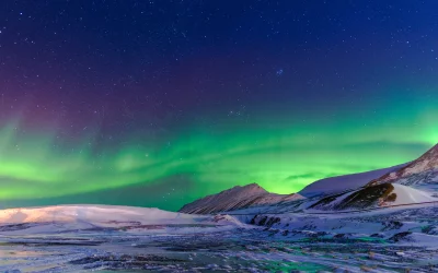 Spectacular Aurora Borealis Lights Up Snowy Arctic Mountains at Night image