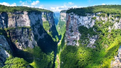 Breathtaking Deep Canyon Landscape with Lush Green Walls and Serene River image