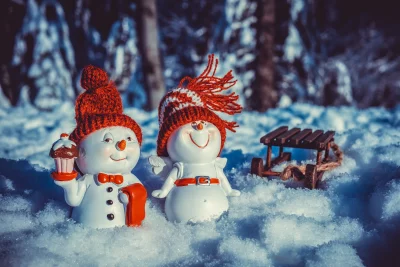 Festive Snowman Couple with Sled on Snowy Winter Field Cinematic Wallpaper image