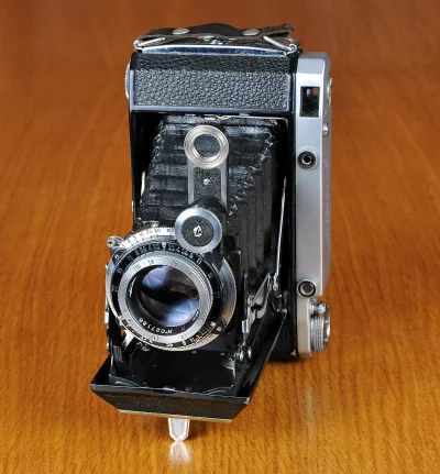 Classic Vintage Folding Camera with Bellows on Wooden Table image