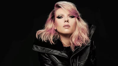 Confident Woman with Pink Blonde Hair and Edgy Style Poses in Leather Jacket image