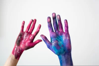 two hands one painted pink and the other painted blue