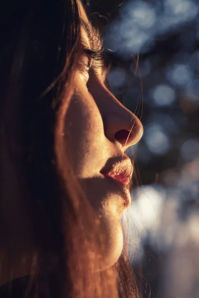 Golden Hour Serenity Woman's Contemplative Profile with Soft Bokeh Background