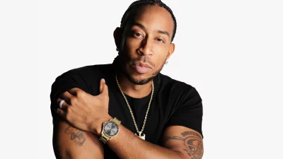 Confident Ludacris Posing with Gold Watch, Chain, and Braids in Studio Portrait image