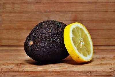 Fresh Ripe Avocado and Zesty Lemon Slice on Rustic Wooden Board image