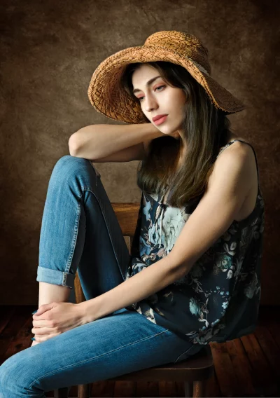 Pensive Woman in Straw Hat Floral Top and Jeans Portrait image