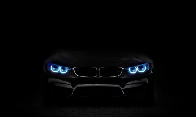 Sleek Black BMW Sports Car with Captivating Blue LED Headlights on Dark Background image