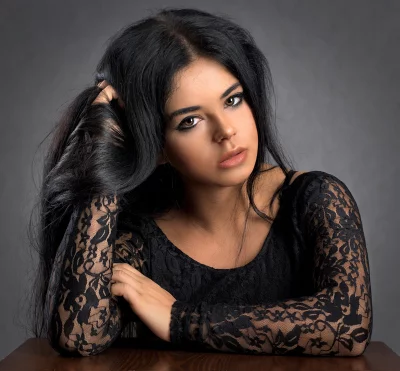 Pensive Young Woman in Black Lace Top with Long Dark Hair Studio Portrait image