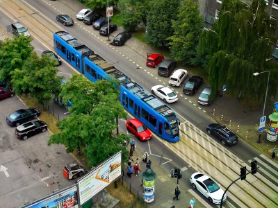 Modern Blue Tram Traversing a Bustling City Street from High Above image