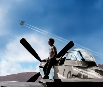 Man on Vintage Aircraft Wing Gazing at Modern Fighter Jets in Blue Sky image
