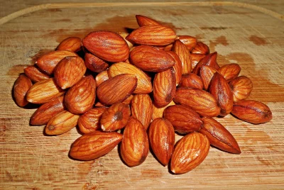Nutritious Roasted Almonds Piled on Rustic Wooden Cutting Board for Healthy Snacking image