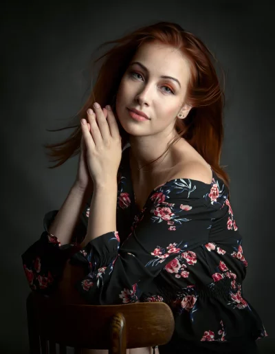 Young Woman with Red Hair in Floral Dress and Clasped Hands image