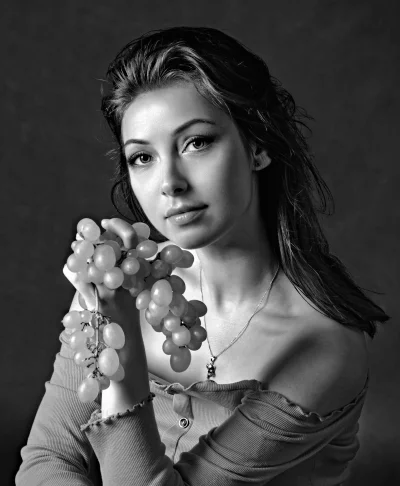 Captivating Young Woman Posing with Grapes in Monochrome Portrait image
