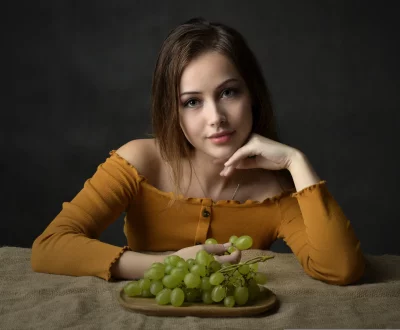 Captivating Young Woman Posing with Green Grapes for Healthy Lifestyle image